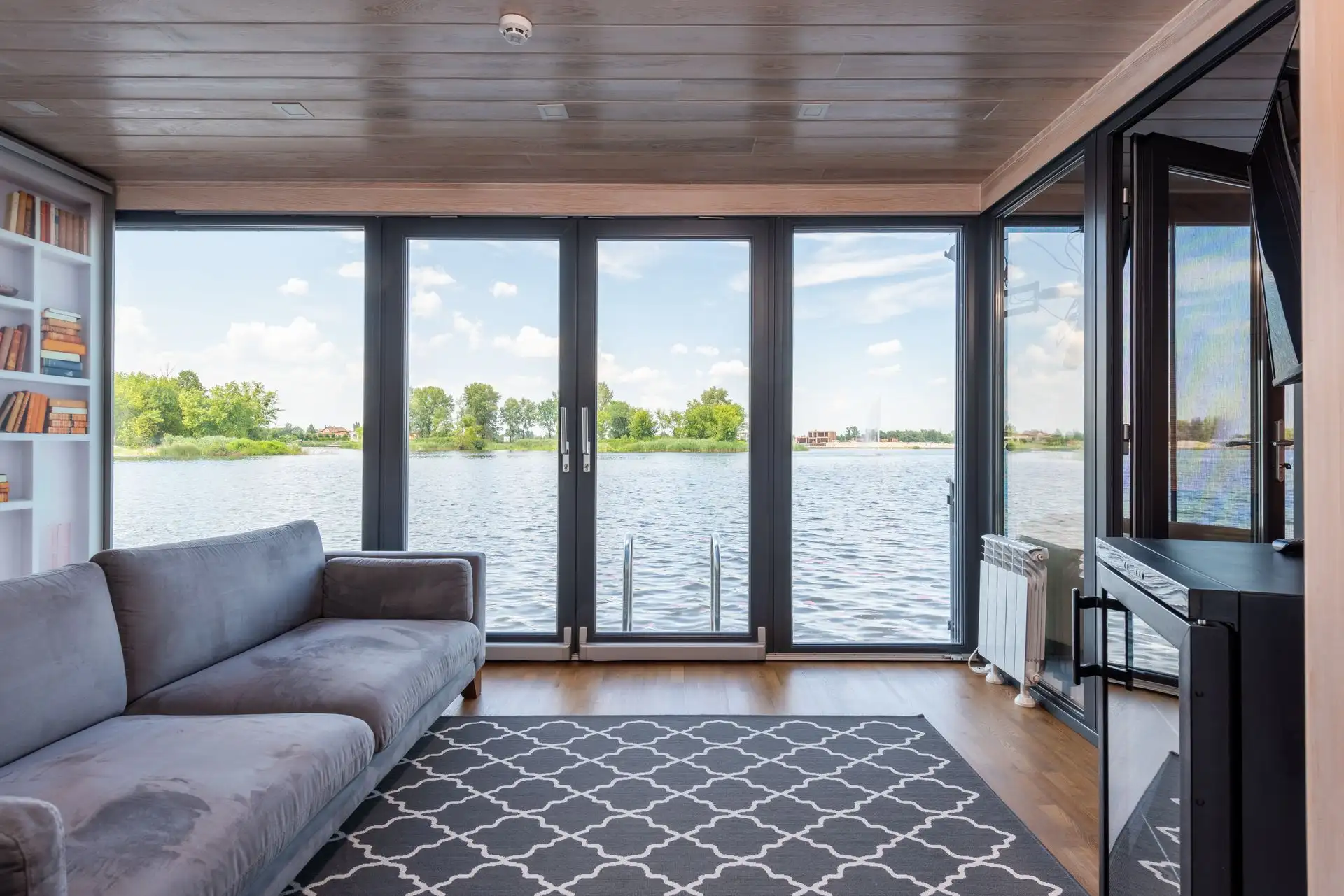 Stue med panoramavinduer mot sjøen og himling i tre